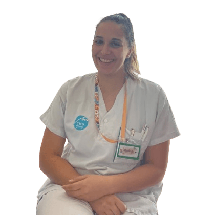 Smiling nurse in uniform with ID badge.